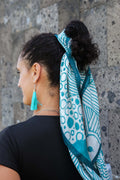 Model wearing the LeMerch TENCEL™ Square Scarf wrapped in her pony tail featuring an original artistic print.