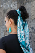 Model wearing the LeMerch TENCEL™ Square Scarf wrapped in her pony tail featuring an original artistic print.