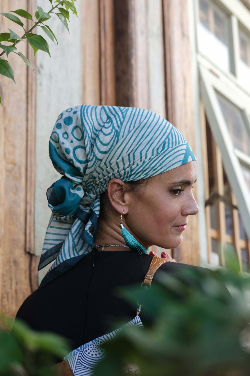 Model wearing the LeMerch TENCEL™ Square Scarf wrapped in her head featuring an original artistic print.