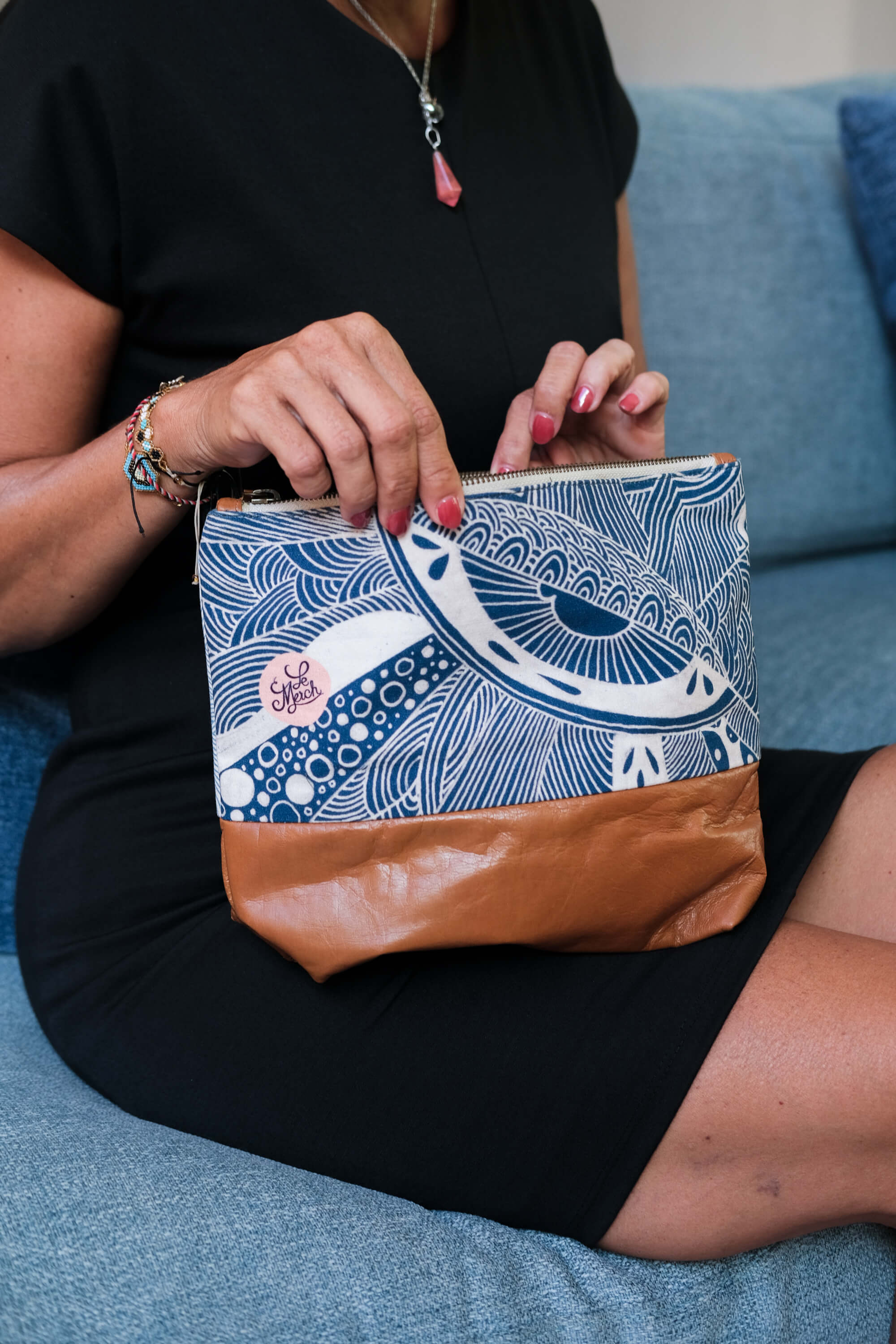 Close-up of the LeMerch Essential Pouch featuring an original artistic print, leather trim, and zipper.