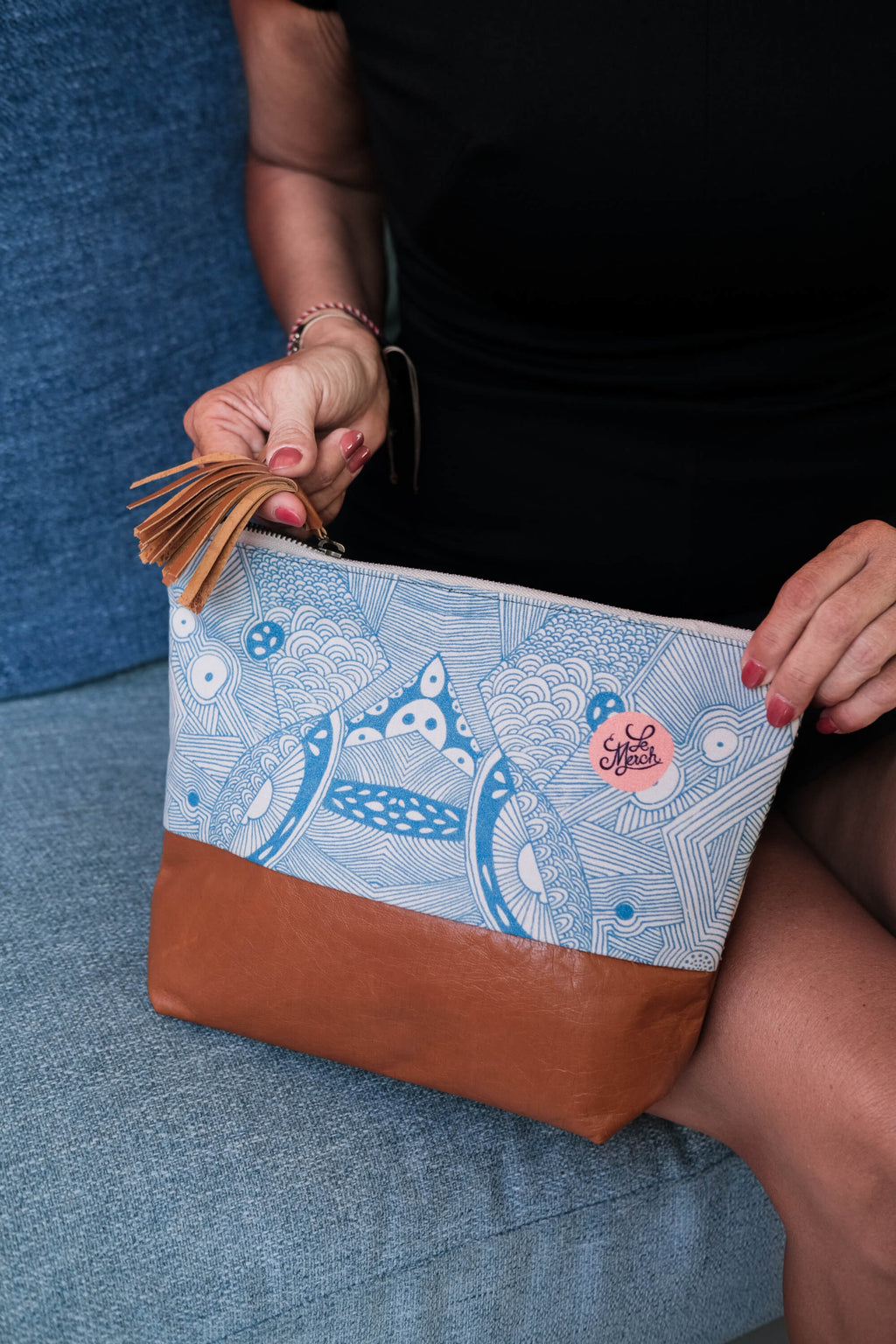 Close-up of the LeMerch Essential Pouch featuring an original artistic print, leather trim, and zipper.