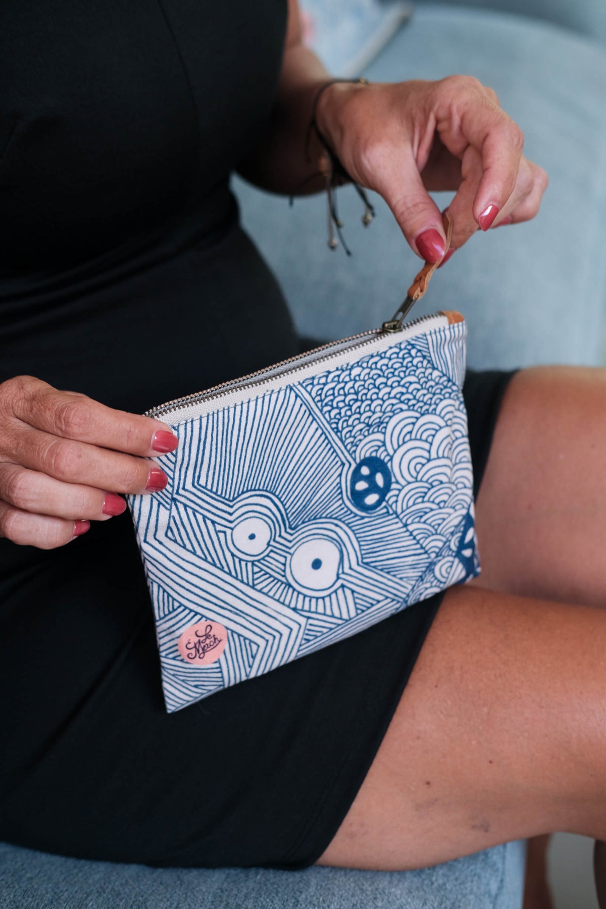 Close-up of the LeMerch Small Pouch, featuring an original artistic print, leather trim, and zipper.