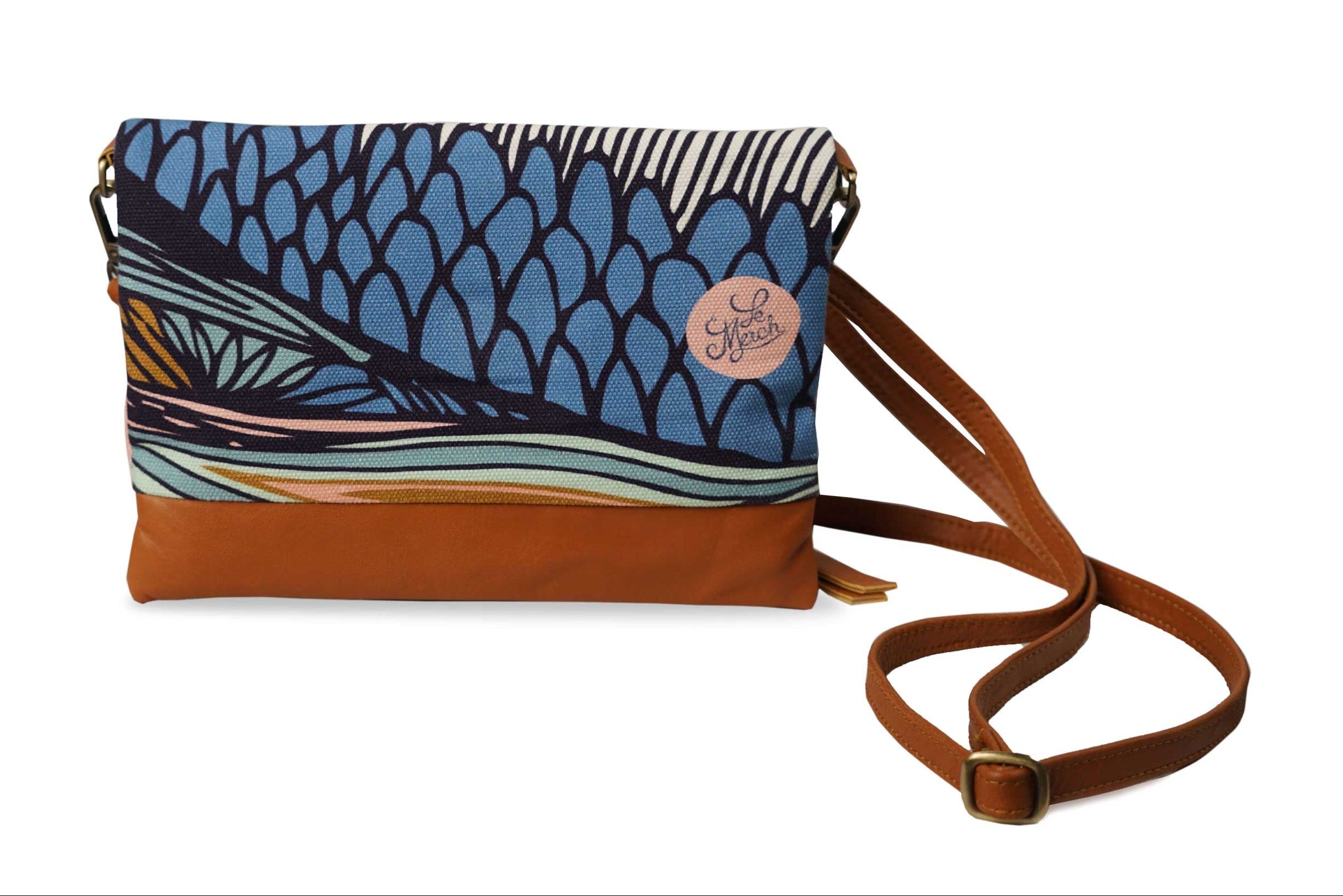 Blue patterned handbag with brown strap on a white background