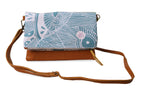 Crossbody bag with a blue patterned flap on a white background