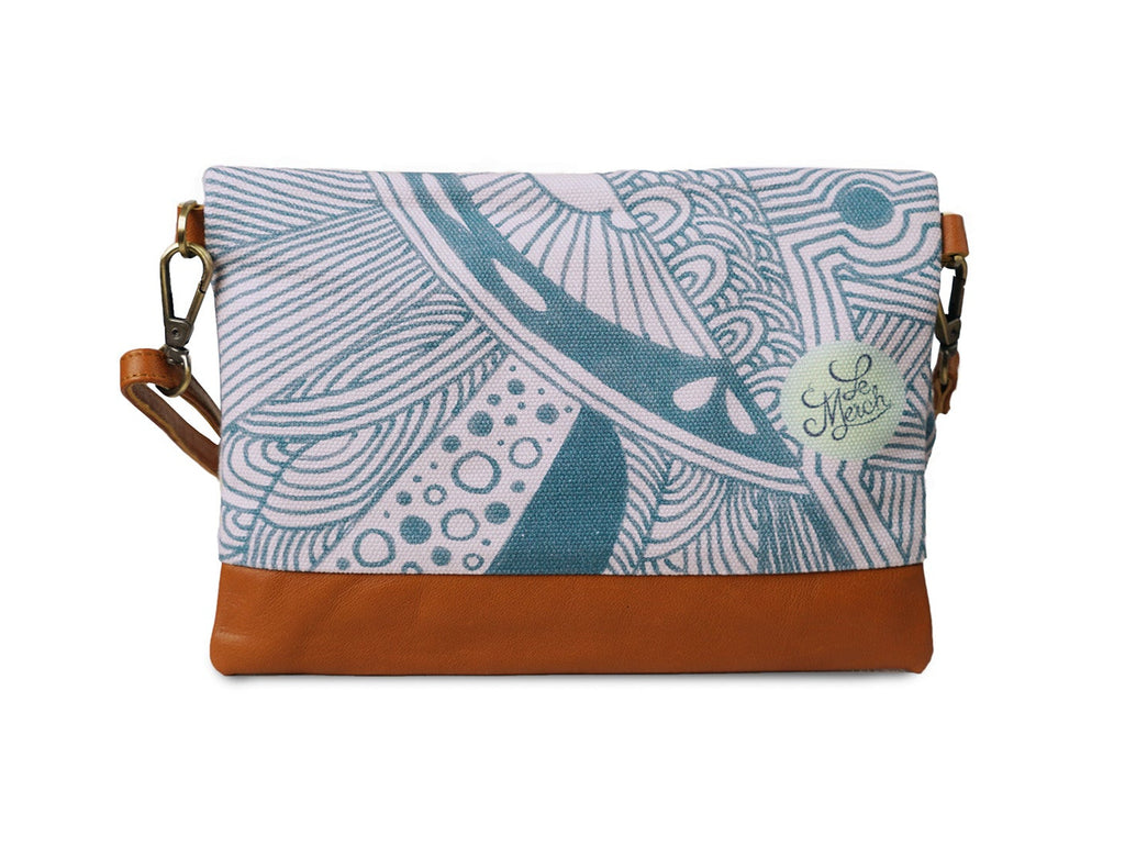Clutch bag with blue patterned top half and brown bottom half on a white background