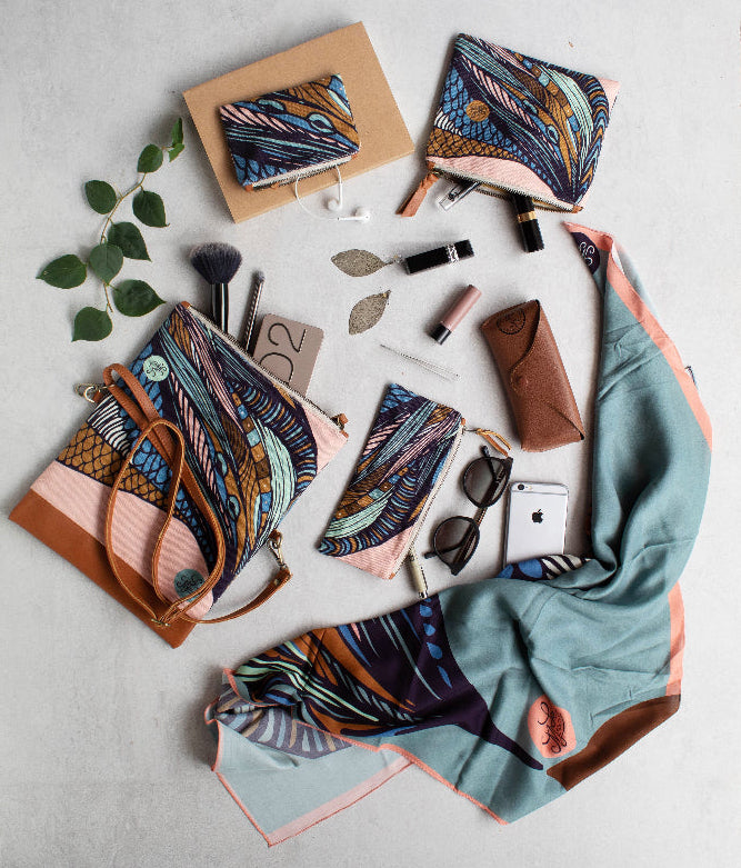 Collection of colorful handbags, scarf and accessories on a light gray surface