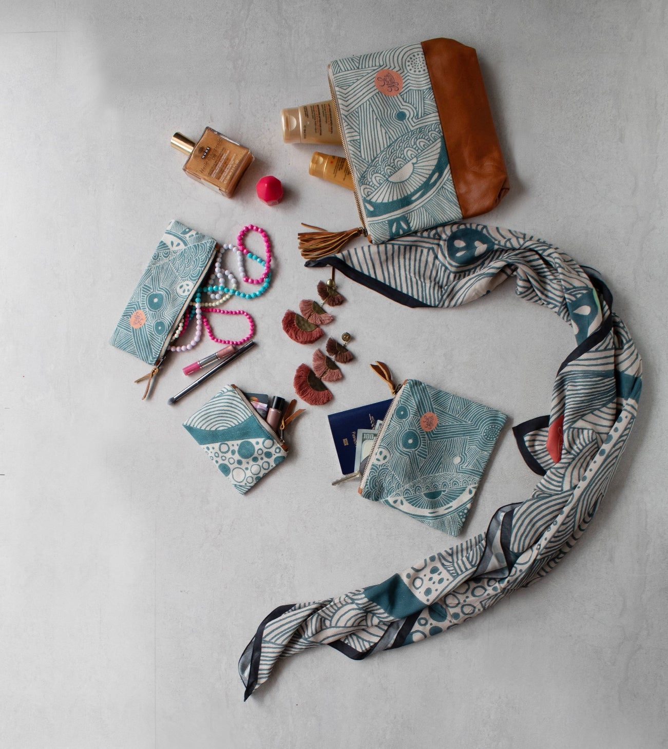 Collection of small bags, a scarf, and accessories on a teal surface