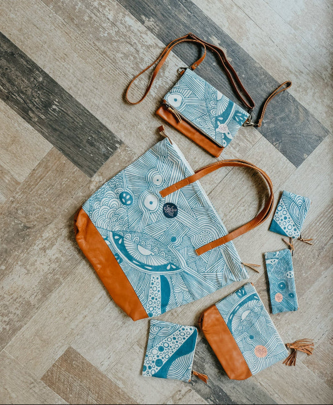 Collection of handbags with blue and brown design on a wooden floor