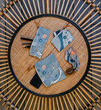 Set of blue patterned pouches on a woven mat with wooden background