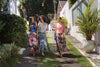 Three women walking, laughing, and wearing LeMerch scarves and handcrafted bags, wrapping themselves in art.